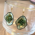 Detailed close-up of green floral earrings with gold hooks on a glass edge - Green Geometric Flower Hook (13#)