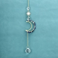 Close-up of golden moon and sun suncatcher with blue stones and clear crystal prism - Blue Lace Agate