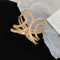 Macro shot of large golden metal hair claw clip with unique twisted texture and glossy finish - Rope Texture Open Bracelet / Gold