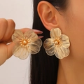 Detail of oversized gold floral stud earrings with intricate hollow wire mesh petals - Stud Earrings (02) / KC Gold