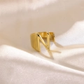Adjustable gold letter N ring with a wide polished band on elegant cream silk background - Letter N / Gold