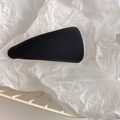 Macro shot of a black fabric triangle hair clip on textured paper in a mesh basket - Black