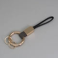 Porte-clés créatif en cuir noir avec anneau en métal doré et lanière élégante - Gris + Or