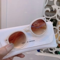 Dettaglio occhiali da sole rotondi avorio per bambini e custodia in ecopelle con logo - Montatura bianca con lente sfumata tè