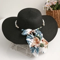 Détail d'un chapeau de paille noir à larges bords avec ruban fleuri et perles - Noir