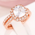 Dettaglio macro di anelli halo in oro rosa con zircone taglio cushion e pavé di gemme - US 7 / Oro rosa