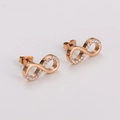 Vue macro des boucles d'oreilles signe infini or rose avec cristaux pavés étincelants - Boucles d'oreilles en or rose
