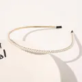 Macro detail of thin gold headband with white pearls on a minimalist white tray - Single Row Small Pearls
