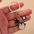Portachiavi con pinguino carino, stella e padella con uovo su anello in oro - Pinguino