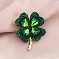Elegant gold clover brooch with green rhinestones set against pink silk fabric - Gold Green Rhinestone Clover (9348-2)