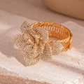Detailed macro view of gold-tone geometric flower bracelet with sparkling rhinestones - Flower Open Bangle / Gold