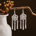 Detail of silver-finish hollow rose earrings with three hanging tassels on a branch - Rose Hollow Three Tassels