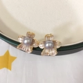 Détail de boucles d'oreilles fleur avec perle gris-mauve, émail blanc et accents dorés - Gris