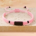 Macro view of pink hand-woven adjustable cord bracelet with black rectangle centerpiece - Pink (Black Plate)