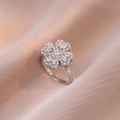 Silver four-leaf clover rotating ring with sparkling zircons on soft beige fabric - Rotating Ring (J0006) / Steel