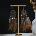 Close-up of bohemian hollow metal earrings with ethnic beads and brown gradient feathers - Antique Bronze Red and White Feather Style(E4576)