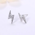 Macro detail of lightning bolt stud earrings with white cubic zirconia and s925 silver - White Gold