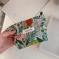 Detail of green floral jacquard mini pouch with simple wish label and zipper closure - Green And Red Flower Bush