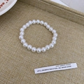 Detailed view of white circular synthetic pearls on an elegant woven display tray - 21# Bracelet-8mm White Beads-Elastic