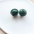 Two forest green 22mm metal craft bells with hanging rings on a white tray - Army Green