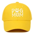 Close-up of white Dog Mom embroidery and paw print on yellow cotton baseball cap fabric - Yellow