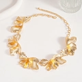 Detailed macro view of golden metal petal necklace with intricate textured leaf details - Necklace-Gold Flower