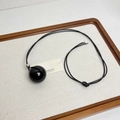 Close-up of a long minimalist necklace with a glossy black spherical pendant and wax cord - Minimalist Black Ball Pendant (Z-3128)