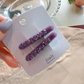 Detailed macro of two purple rhinestone hair clips on a white display card holder - Full Rhinestone Purple Pair