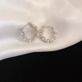 Eleganti orecchini a cerchio ondulati in argento con perle e diamanti su seta bianca - Perla d'Argento