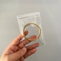 Golden smooth metal bangle stored in a portable clear PVC zip lock jewelry bag - 30 Micron 8x12cm Resealable / 100 Pcs/Pack