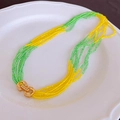 Collier de perles vert et jaune avec fermoir doré de style Gancini sur une assiette blanche - Vert Jaune (125# Collier)