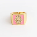 Macro view of gold Hamsa hand ring with pink enamel square and white zircon accents - Adjustable Open / Pink