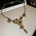 Dettaglio della collana vintage a fiori con cristalli marroni e verdi su fondo beige - Collana-Oro-Verde-Marrone