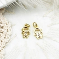 Close-up of gold-tone mini boy and girl charms on white lace and feather background - Little Figure