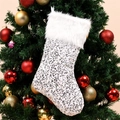 Sparkling silver sequin Christmas stocking with plush white cuff hanging on a festive tree - Silver
