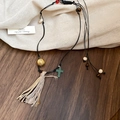 Détail du collier pendentif fleur bohème avec glands et perles sur fond de lin - 14# Collier-Noir-Café (Gland de Croix)