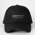 Detail of embroidered 'one day at a time' text and colored hearts on black cotton cap - One Size / Black
