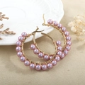 Macro detail of handmade gold hoop earrings with light purple pearl beads and wire wrap - Lavender