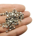 Nahaufnahme von geometrischen tibetischen Silberperlen in der Hand für DIY-Schmuck - Antiksilber