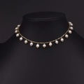 Handgemaakte ketting met zoetwaterparels en gouden kwastjes op een zwarte buste - Nette Rij Parelstijl
