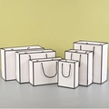 Detail view of six white paper gift bags in various sizes with black rope handles - White with Black Frame / 15*8*21 Vertical