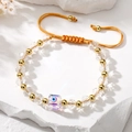 Minimalist evil eye crystal bead bracelet with gold plated accents on woven gold cord - Purple