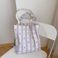 Bolso de lona con rayas violetas claras y estampado de lavanda sobre una silla - Campanilla a Rayas Blanco Púrpura