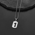 Dettaglio della collana con ciondolo numero uno in acciaio argento su sfondo in pietra - Numero 1