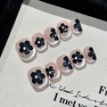 Handgemaakte kunstnagels met zwarte bloemen en strikjes op een roze parelmoer basis - XS