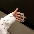Bracciale a catena cubana argentata con strass indossato al polso in una posa trendy - 18cm (Standard)