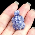 Mini sea turtle gemstone figurine in blue sodalite stone held by hand for scale - Blue Spot Stone