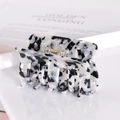 Detail of square acetate hair claw with black and white marble pattern and gold spring - Black and White Checkered