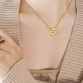 Collana a sfere dorata con ciondolo rotondo Love Me indossata su un maglione - 40+5cm / Oro