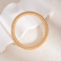 Gros plan d'un bracelet spirale multicouche doré sur une surface texturée élégante - Bracelet jonc tissé torsadé multifil doré (L714)